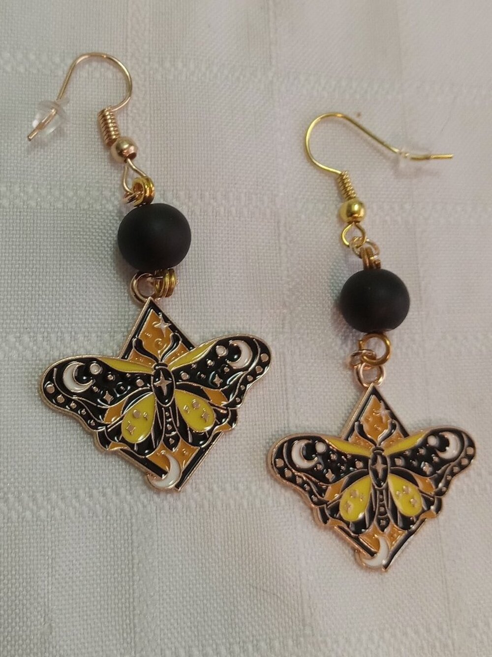 Handmade gold-colored earrings with multicolored enameled butterflies and beads